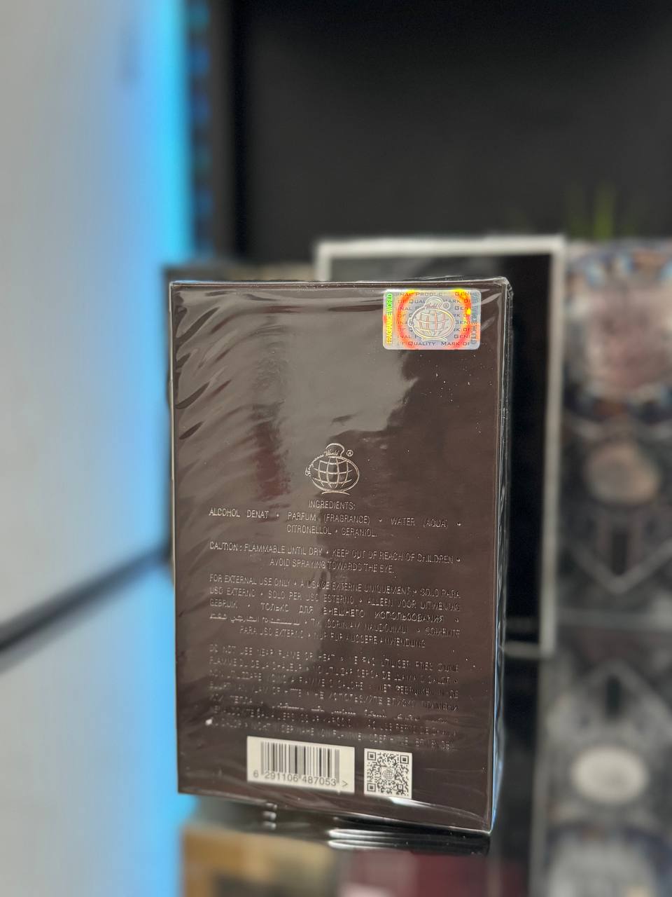 Caja de perfume de Fragrance World con detalles en la parte posterior y etiqueta de autenticidad